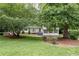 Beautifully landscaped front yard featuring mature trees, lush greenery, and a classic two-story home with gray shutters at 2786 Georgian Ter, Marietta, GA 30068