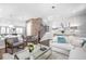 Bright living room features modern lighting, hardwood floors, brick accent wall and open concept to dining area at 410 Concord St, Alpharetta, GA 30009