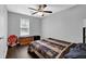 Simple bedroom with dark wood-look flooring and neutral walls is furnished with a bed, dresser and stop sign art at 5461 Forest Path Ct, Stone Mountain, GA 30088