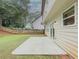 A view of the backyard with a concrete patio, fence, and green grass at 750 Summerstone Ln, Lawrenceville, GA 30044