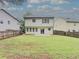 Spacious backyard view showcases green lawn, wooden fence, and back of house at 750 Summerstone Ln, Lawrenceville, GA 30044