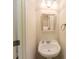 Well-lit half bath featuring pedestal sink, framed mirror, and tile floors at 750 Summerstone Ln, Lawrenceville, GA 30044