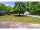 Backyard view with mature trees, grassy areas, and detached garage at 2021 Sherwood Dr Se, Marietta, GA 30062