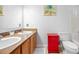 Functional bathroom featuring double sinks with wood cabinets and a red cabinet at 2021 Sherwood Dr Se, Marietta, GA 30062