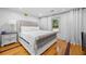 Comfortable bedroom with hardwood floors, a large bed with a tufted headboard, and natural light from the window at 2021 Sherwood Dr Se, Marietta, GA 30062