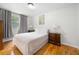 Cozy bedroom featuring hardwood floors, window with curtains and bedside tables and lamps at 2021 Sherwood Dr Se, Marietta, GA 30062