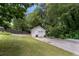 Backyard detached garage with two garage doors, side door, and gravel driveway at 2021 Sherwood Dr Se, Marietta, GA 30062
