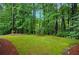 Private, verdant backyard featuring a meticulously maintained lawn and mature trees at 3522 Estates Landing Nw Dr, Kennesaw, GA 30144