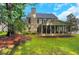 Expansive backyard view showcasing well-maintained lawn, mature trees, and screened porch at 3522 Estates Landing Nw Dr, Kennesaw, GA 30144