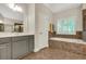 Primary bathroom showcasing a soaking tub, dual vanities, and tiled floor at 3522 Estates Landing Nw Dr, Kennesaw, GA 30144