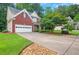 Exterior view of a brick home with a wide driveway, lush lawn, and mature trees at 3522 Estates Landing Nw Dr, Kennesaw, GA 30144
