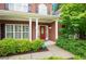 Close-up of a brick home's entrance, featuring a red door and well-kept landscaping at 3522 Estates Landing Nw Dr, Kennesaw, GA 30144