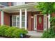 Inviting front entrance with a red door, brick facade, and manicured shrubbery at 3522 Estates Landing Nw Dr, Kennesaw, GA 30144