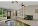 Bright sunroom featuring a heated pool with a stone waterfall and access to the backyard at 3522 Estates Landing Nw Dr, Kennesaw, GA 30144