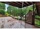 Wooden deck features benches and stairs offering a view of a beautifully landscaped backyard with a pool at 209 Breckenridge Ct, Canton, GA 30115