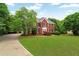 Landscaped exterior of a red brick two-story home with a large front lawn at 209 Breckenridge Ct, Canton, GA 30115
