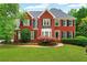 Beautiful red brick home with lush front yard, black shutters, and manicured landscaping at 209 Breckenridge Ct, Canton, GA 30115