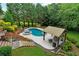 Backyard featuring a luxurious pool, hot tub, covered seating area, and lush landscaping for ultimate relaxation at 209 Breckenridge Ct, Canton, GA 30115
