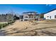 Back exterior of the home featuring a large, gently sloping yard and covered porch at 2551 Kilgore Rd, Buford, GA 30519
