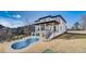 A modern home features a walk-out basement and deck overlooking a yard with a pool at 2551 Kilgore Rd, Buford, GA 30519