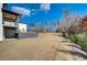 Back of the home showing a concrete patio with access to the backyard, an adjacent side yard and retaining wall at 2551 Kilgore Rd, Buford, GA 30519
