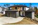 A modern two-story home featuring a three-car garage, brick accents, and a stylish black front door at 2551 Kilgore Rd, Buford, GA 30519