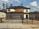 Contemporary home with a three-car garage, black accents, and gated driveway at 2551 Kilgore Rd, Buford, GA 30519