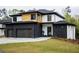 Modern home featuring a three-car garage, black brick accents and manicured lawn at 2551 Kilgore Rd, Buford, GA 30519
