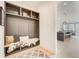 Inviting hallway featuring a built-in bench with storage and a glimpse into the open kitchen area at 2551 Kilgore Rd, Buford, GA 30519