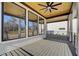 View of the covered back porch with a ceiling fan, multiple windows and gray composite flooring at 2551 Kilgore Rd, Buford, GA 30519