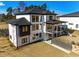 A two-story residence featuring a walkout basement and deck overlooking a spacious yard with modern railing at 2551 Kilgore Rd, Buford, GA 30519