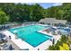 Large community swimming pool surrounded by lounge chairs, tables, umbrellas, and lush greenery, perfect for relaxation and recreation at 3430 Rocky Springs Ct, Marietta, GA 30062
