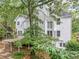 Charming back exterior with a deck, patio, white siding, and beautiful landscaping at 5190 Beech Forest Sw Dr, Lilburn, GA 30047