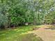 Expansive backyard with a storage shed, mature trees, and green lawn, perfect for outdoor activities at 5190 Beech Forest Sw Dr, Lilburn, GA 30047
