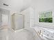 Bright bathroom featuring a shower, a soaking tub with jets and tile floors at 5190 Beech Forest Sw Dr, Lilburn, GA 30047
