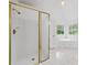 White bathroom featuring a shower with gold trim, a soaking tub and tile floors at 5190 Beech Forest Sw Dr, Lilburn, GA 30047
