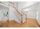Bright foyer with wood floors, staircase with white railings, and view into the dining area at 5190 Beech Forest Sw Dr, Lilburn, GA 30047