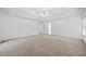 Spacious main bedroom with neutral carpet, ceiling fan, tray ceiling and large windows at 5190 Beech Forest Sw Dr, Lilburn, GA 30047