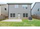 Backyard featuring a grey two-story house with a patio and a small patch of grass at 2317 Church Street, Hampton, GA 30228