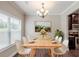 Charming dining area featuring a wooden table set for six, a large window, and neutral decor at 2317 Church Street, Hampton, GA 30228
