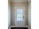 Clean entryway featuring a white door with window, neutral walls, and dark wood floors at 2317 Church Street, Hampton, GA 30228