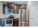 Modern kitchen featuring stainless steel appliances, granite countertops, and dark wood cabinets at 2317 Church Street, Hampton, GA 30228