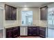 Stylish kitchen showcasing granite countertops, dark wood cabinets, and a stainless steel dishwasher at 2317 Church Street, Hampton, GA 30228