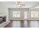 Neutral living room featuring a fireplace, ceiling fan, window, door, and dark wood flooring at 2317 Church Street, Hampton, GA 30228