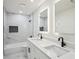 Bright bathroom featuring double sinks, modern fixtures, and a tiled shower-tub combination at 3455 Broxton Mill Way, Snellville, GA 30039