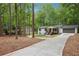 Charming home with a long driveway and a beautifully landscaped front yard surrounded by mature trees at 3455 Broxton Mill Way, Snellville, GA 30039