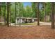 A charming home nestled among tall trees, featuring a long driveway, a covered porch, and fresh landscaping at 3455 Broxton Mill Way, Snellville, GA 30039