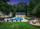 Lush backyard featuring a sparkling pool, fire pit, and ample seating for entertaining at 704 Branchview Ct, Mcdonough, GA 30252