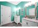 Bathroom features dual sinks, stylish mirrors, and bright aqua walls at 704 Branchview Ct, Mcdonough, GA 30252