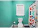 A turquoise bathroom including a toilet, a window with blinds and colorful shower curtain at 704 Branchview Ct, Mcdonough, GA 30252